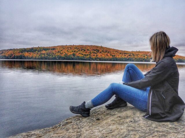 Girl is looking at the Fall colors at Rock Lake in Algonquin Provincial Park