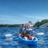 Bruce Peninsula, couple kayaking with ferry to manitoulin island behind them