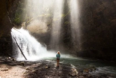 Johnston Canyon girl standing close to waterfalls. 