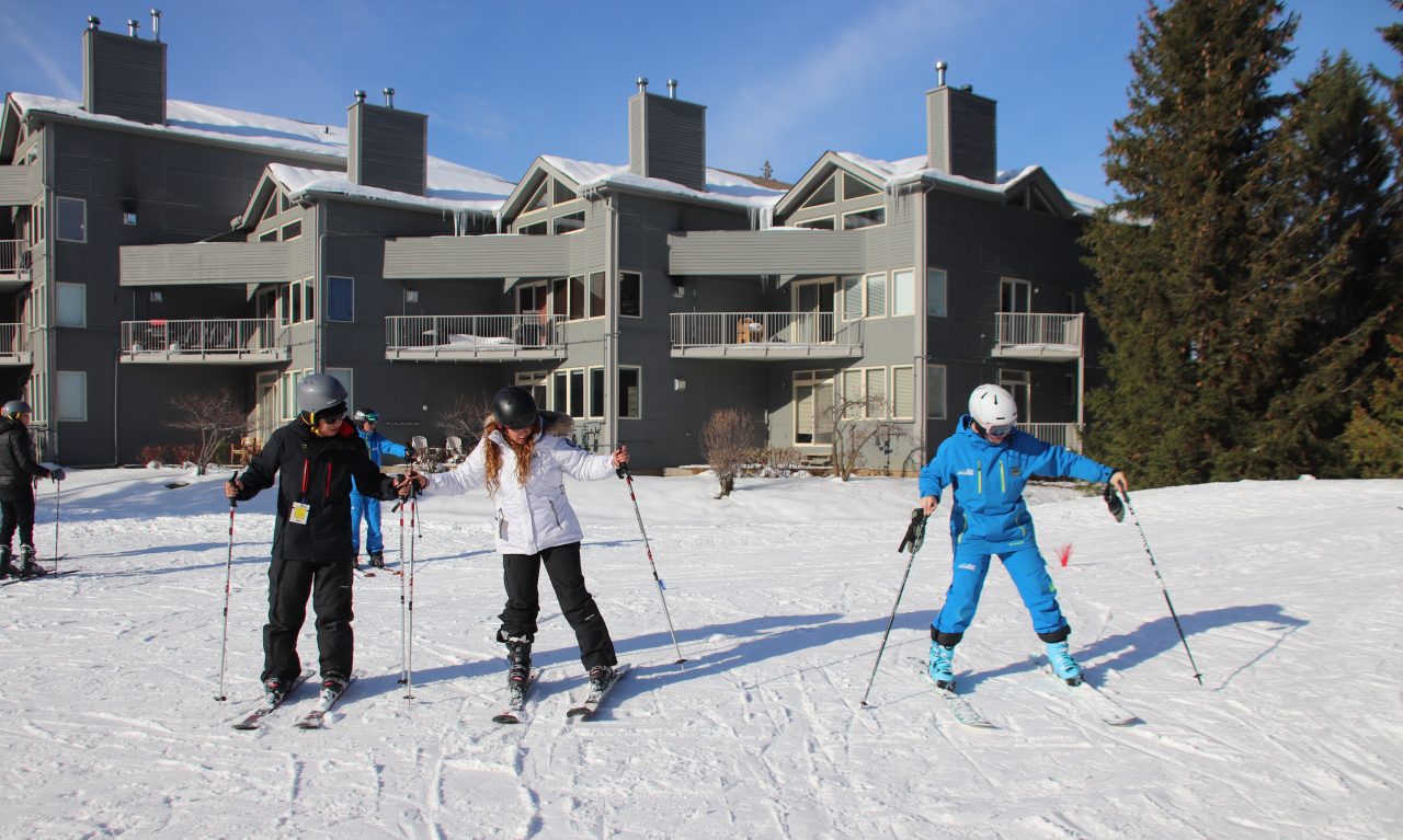 Couple is having a ski lesson with instructor, going up the hill in Blue Mountain